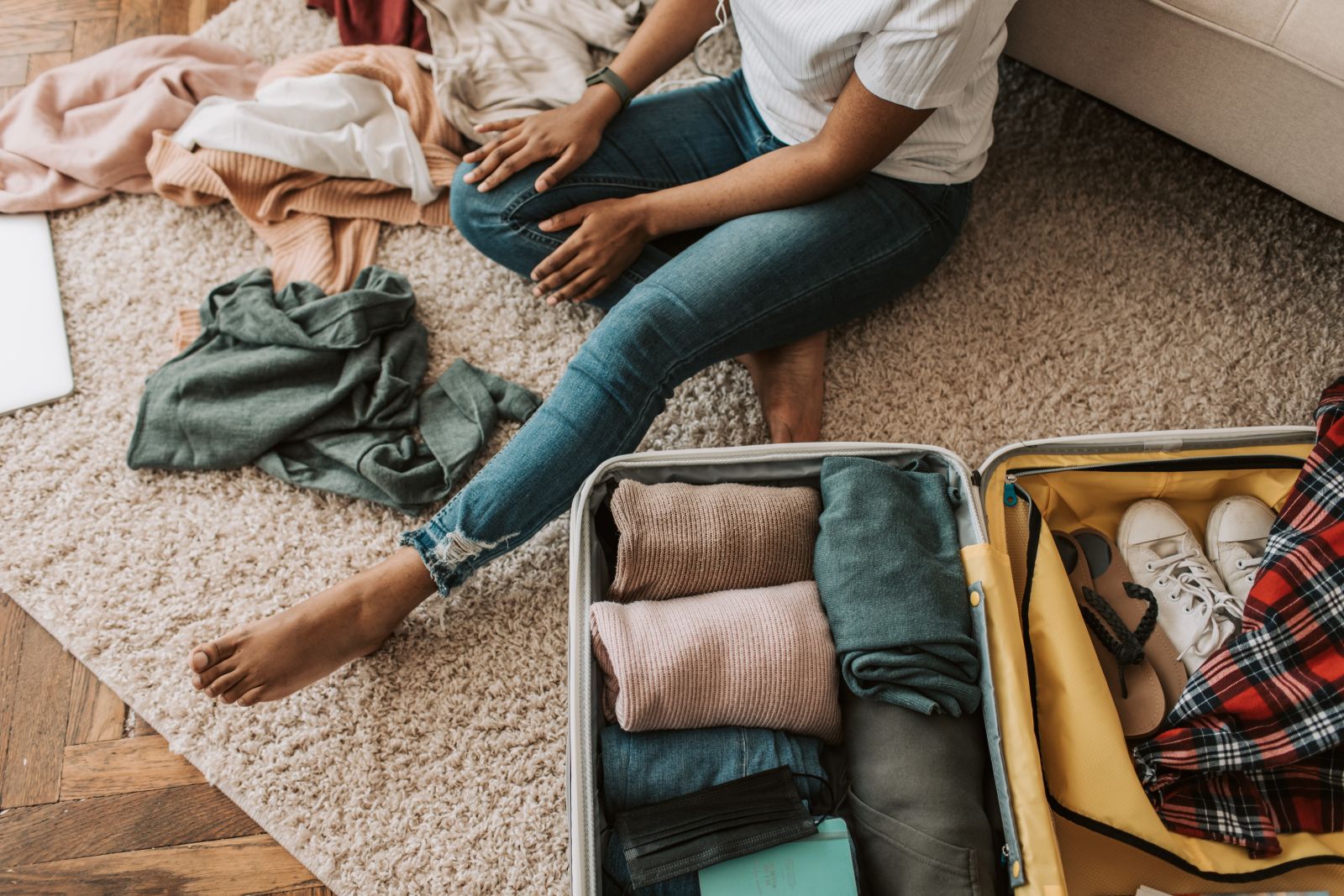 person packing suitcase on wool rug